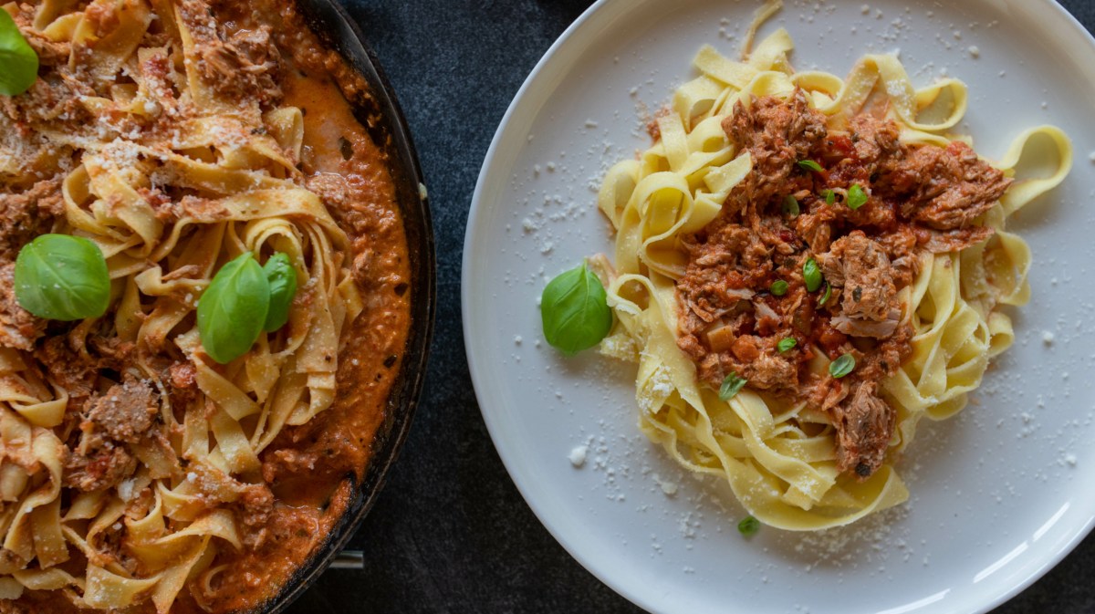 Tagliatelle mit Tomaten-Thunfisch-Soße auf weißem Teller.