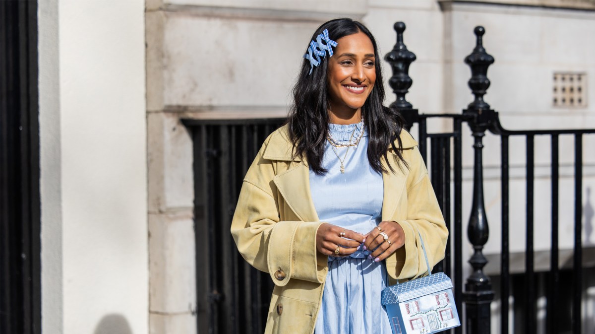 Streetstyle der London Fashion Week im Frühling 2024 mit einem Trenchcoat und hellblauen Kleid