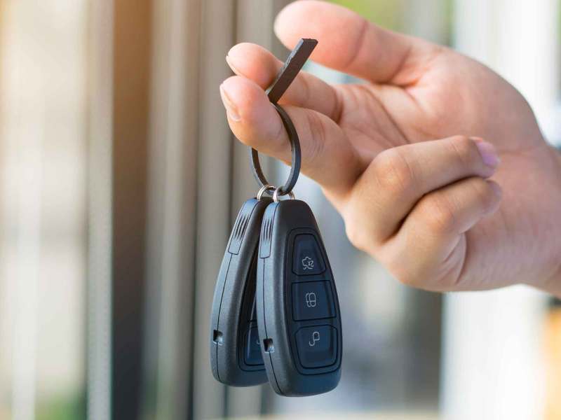 Person hält zwei Autoschlüssel in der Hand.