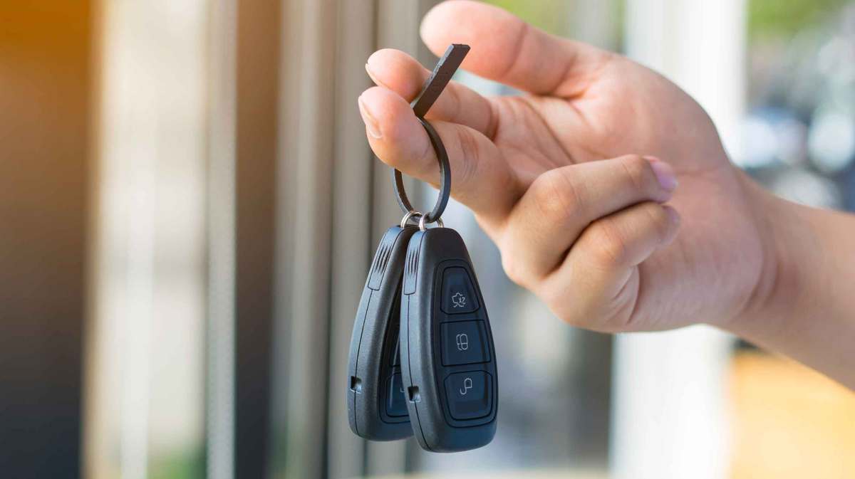 Person hält zwei Autoschlüssel in der Hand.