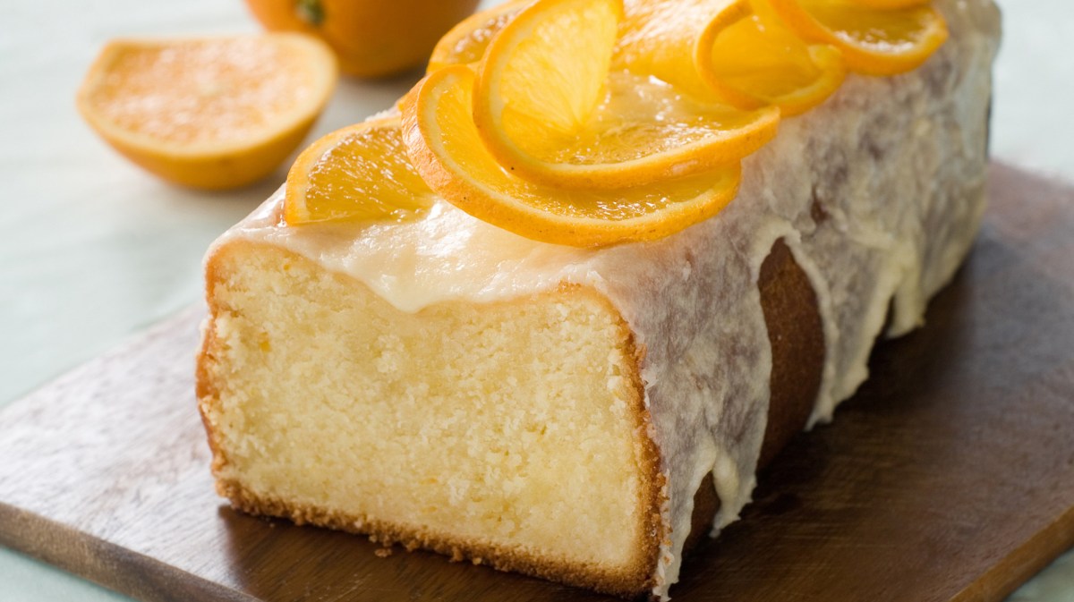 Kastenkuchen mit Orangenglasur und Orangenscheiben.