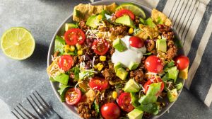 Salat mit Hackfleisch, Tomaten, Avocado und Limette.