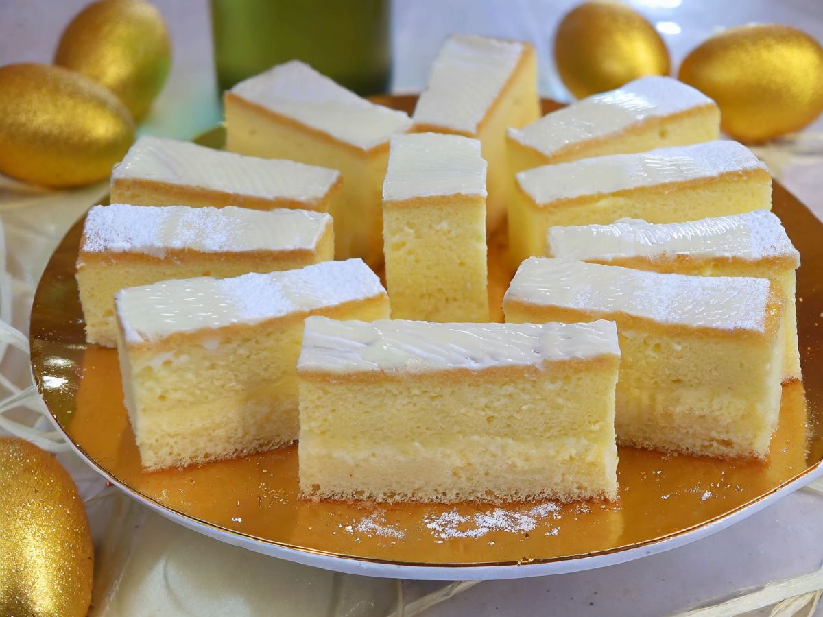 Blechkuchen mit Eierlikör und Frosting auf goldenem Teller daneben goldene Eier