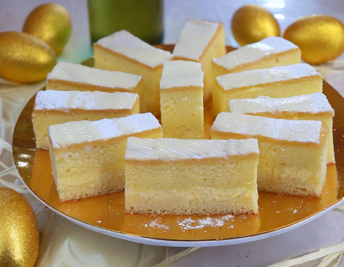 Blechkuchen mit Eierlikör und Frosting auf goldenem Teller daneben goldene Eier