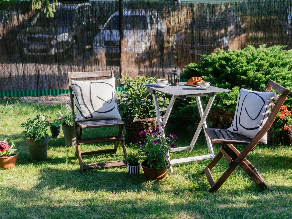 Gartentisch mit Klappstühlen und Kissen