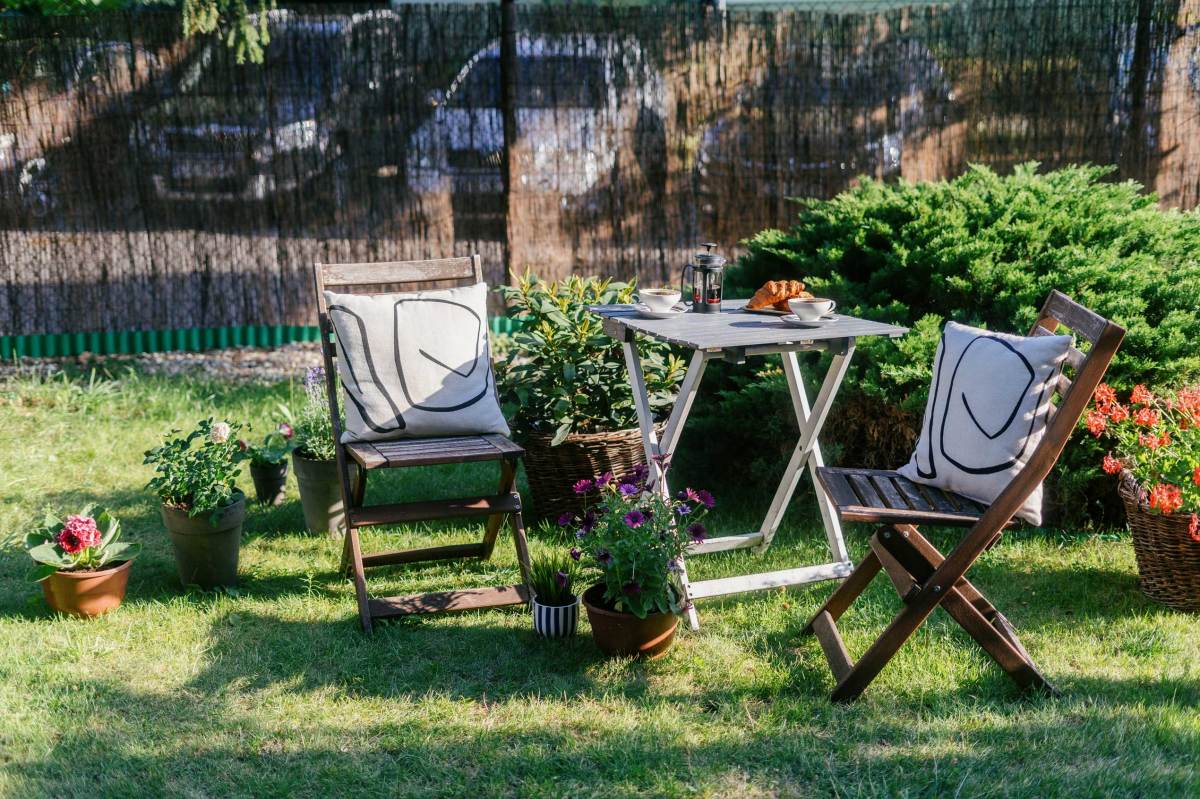 Gartentisch mit Klappstühlen und Kissen