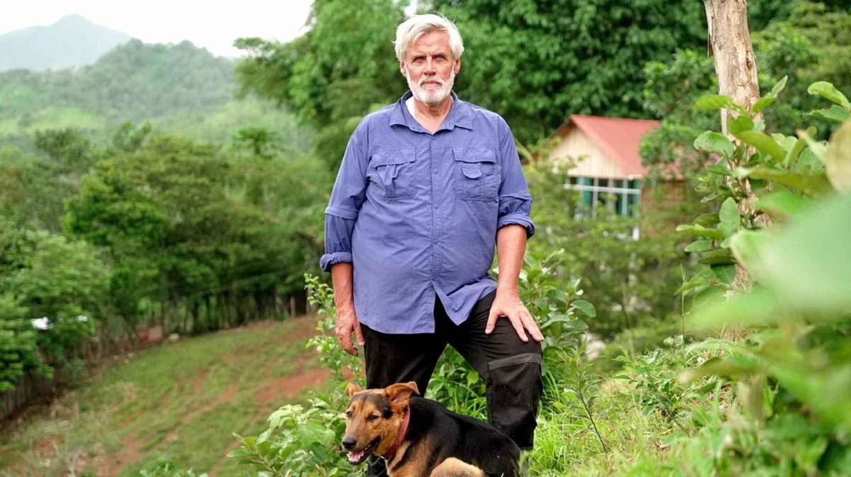 Andreas (63) aus Guatemala mit seinem Hund auf seinem Hof.