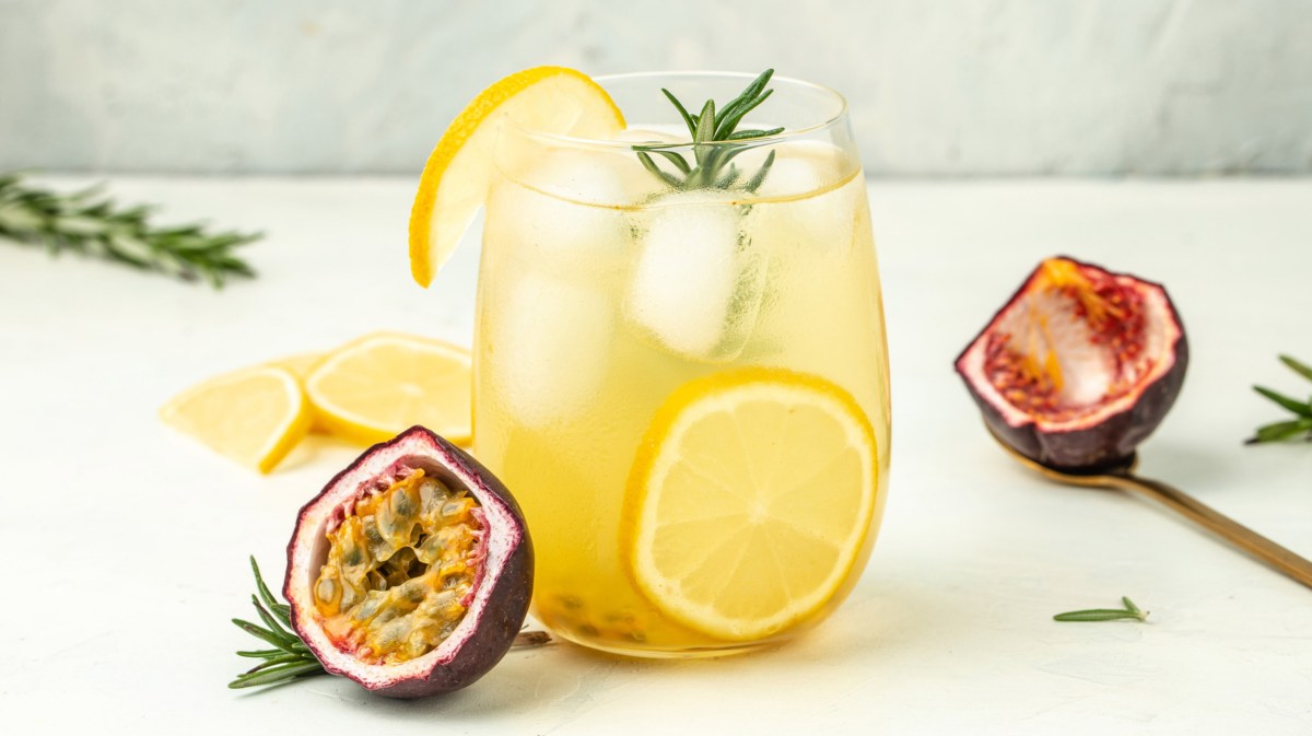 Gelber Cocktail mit passionsfrucht und Eiswürfel.