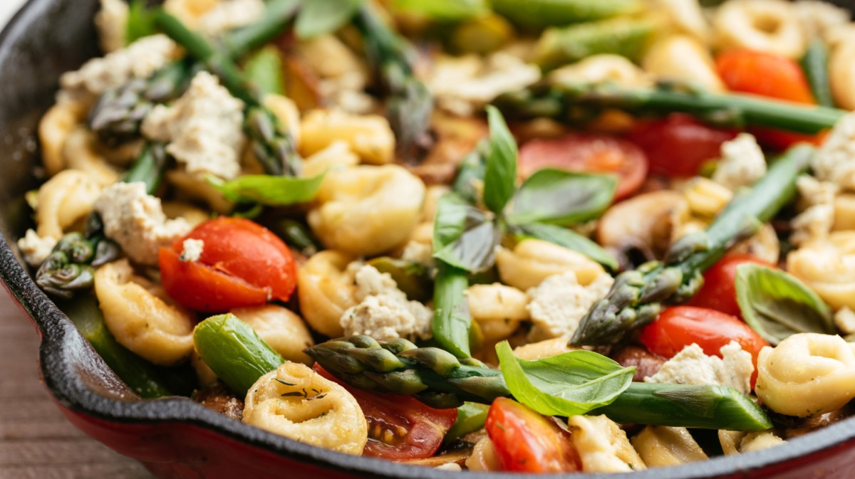 Nudelsalat mit Tortellini, grünem Spargel, Tomaten und Basilikum.