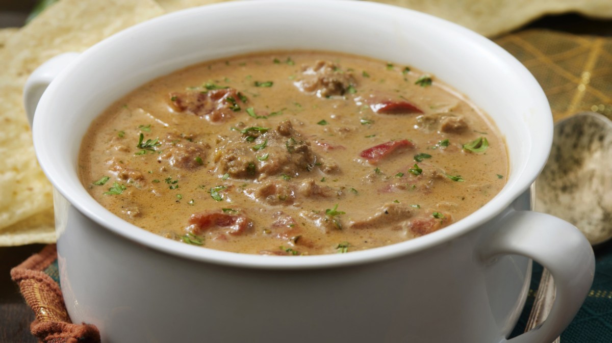 Suppe mit Tomaten, Hackfleisch und Paprika in weißer Schüssel.