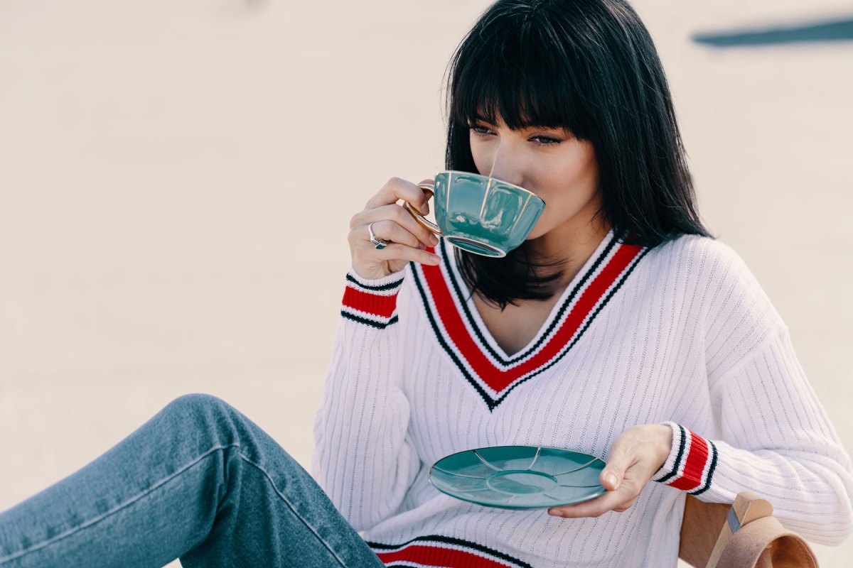 Frau mit dunklen Haaren trinkt Kaffee