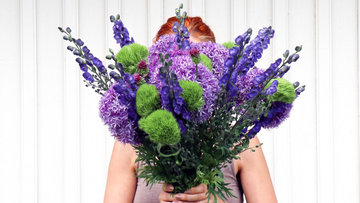 Frau mit Blumenstrauß, unter anderem Allium.