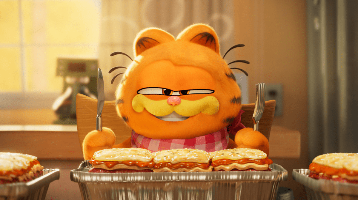 Garfield Animation, der Messer und Gabel in der Hand hält und vor einem Tisch mit Lasagne sitzt.