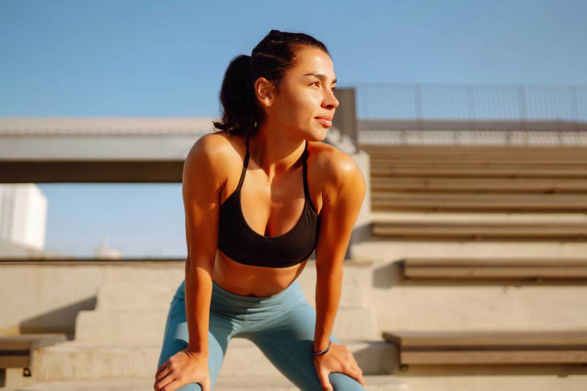 Junge, sportliche Frau beim Training und Stretching im Freien am Morgen.