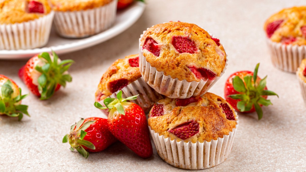 Mehrere Erdbeer-Muffins auf einem weißen Tisch.