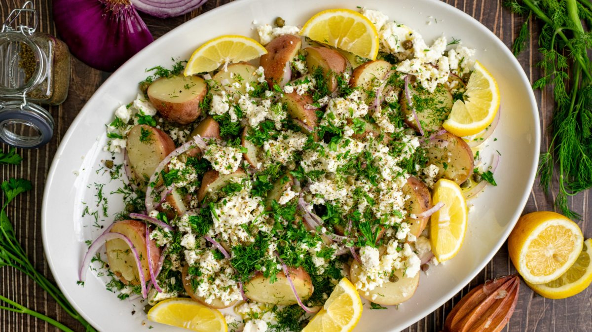 Kartoffelsalat mit Feta und Zitronen auf großem Teller.