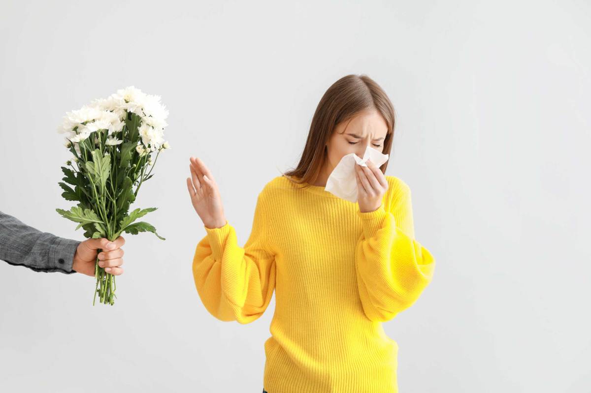 Frau mit Allergie lehnt Blumen ab, die ihr von einem Mann angeboten werden.