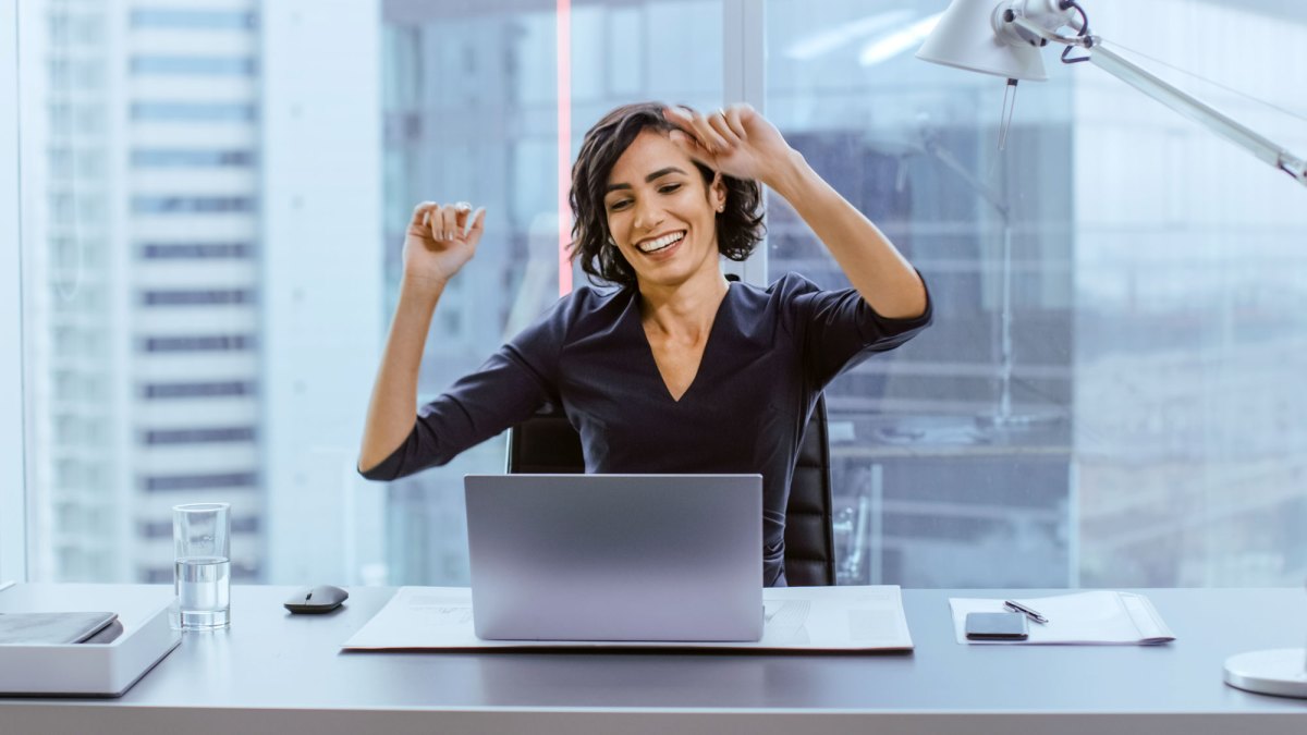 Frau freut sich vor Laptop