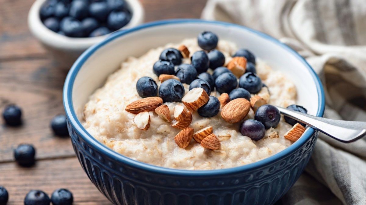 Porridge mit Blaubeeren und Mandeln in einer blauen Schüssel.