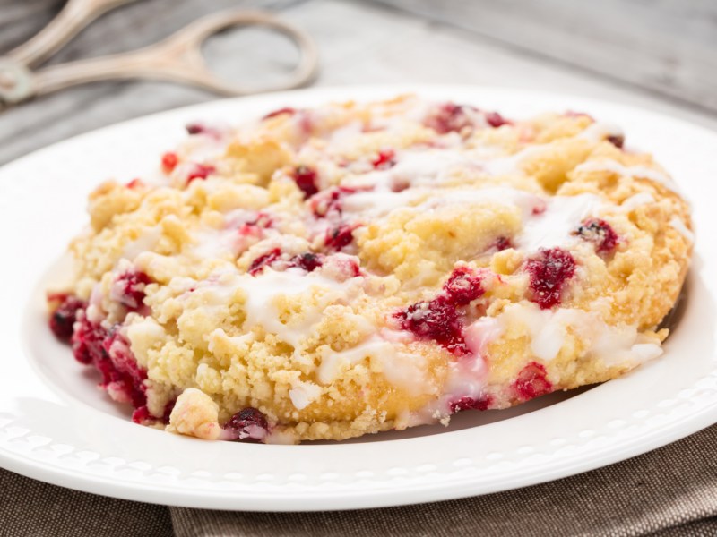 Streuseltaler mit Johannisbeeren auf weißem Teller.