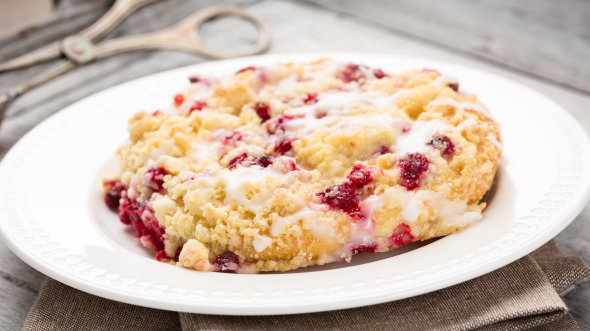 Streuseltaler mit Johannisbeeren auf weißem Teller.