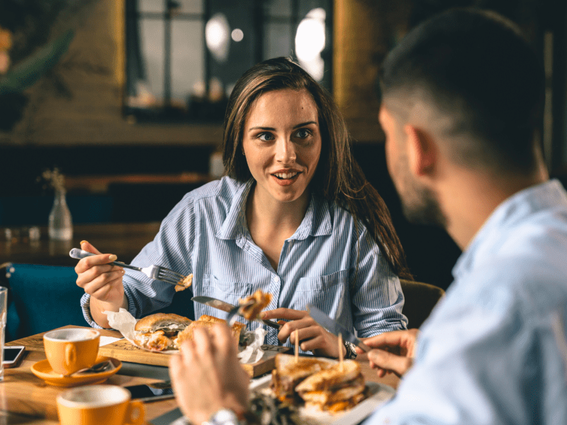 Frau und Mann beim Essen, die sich miteinander unterhalten.