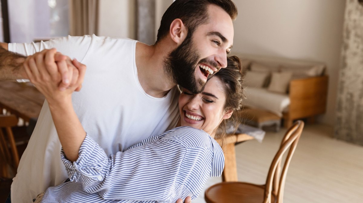 Mann und Frau tanzen im Wohnzimmer