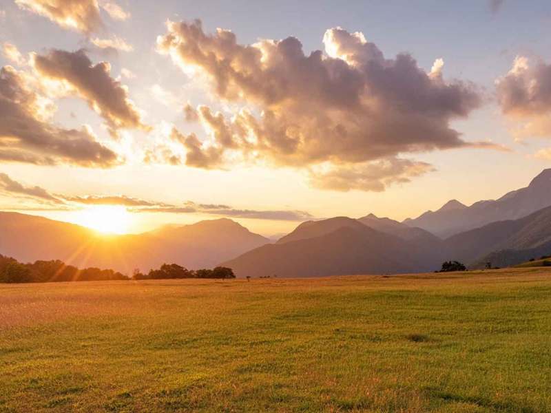 Landschaft mit Bergen im Hintergrund und einem schönen Sonnenuntergang.