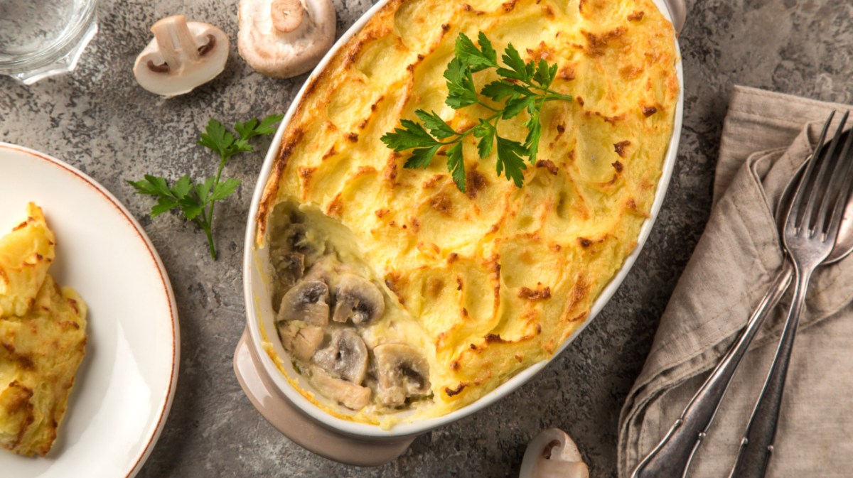 Shepherd's Pie mit Hähnchen und Pilze-Füllung in weißer Auflaufform.