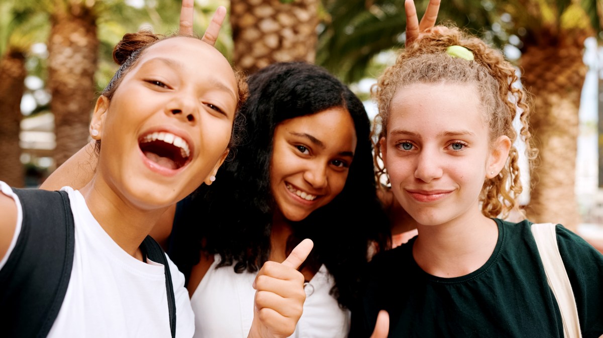 Drei Mädchen, zwischen 12 und 14 Jahren, posieren cool und albern und machen ein Selfie.