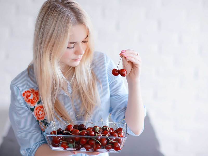 süßes Mädchen isst Kirsche / Konzept gesunde Ernährung