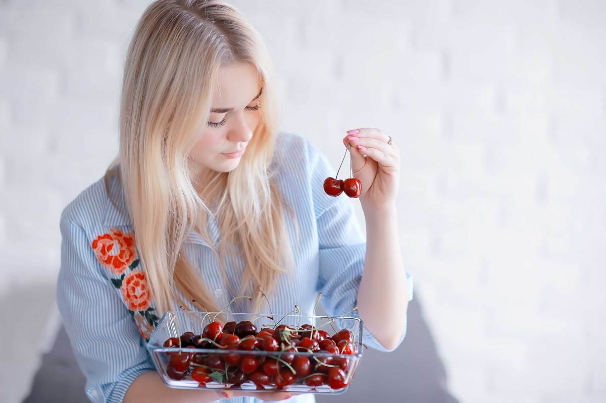 süßes Mädchen isst Kirsche / Konzept gesunde Ernährung