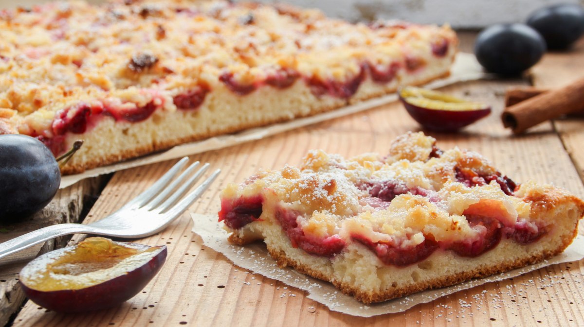 Pflaumenkuchen vom Blech auf einem Stück Backpapier.