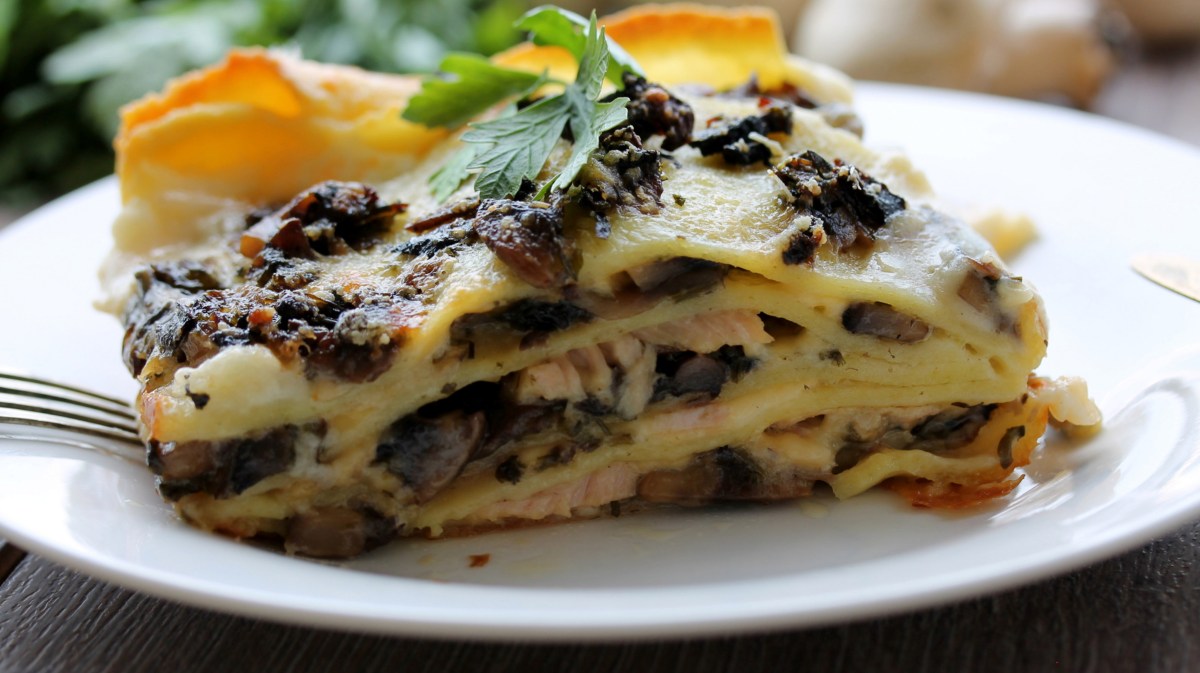 Stück Pilz-Lasagne auf einem weißen Teller.