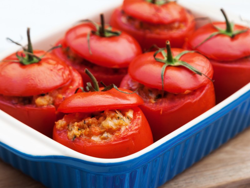 Gefüllte, große Tomaten in einer blauen Auflaufform.