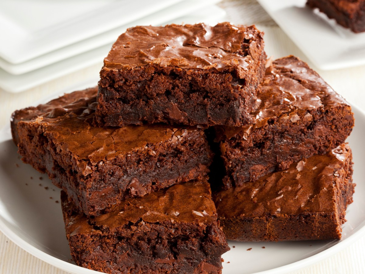 Mehrere Brownies aufeinander gestapelt auf einem weißen Teller.