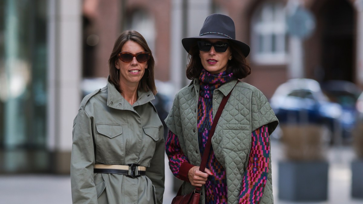 Frauen mit gemusterten Herbst-Kleidern und grünen Jacken im Utility-Stil