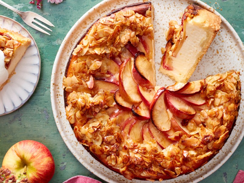 Apfelkuchen mit Bienenstich Topping auf einem herbstlich gedeckten Tisch.