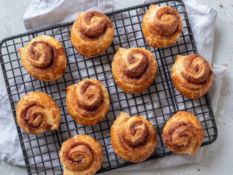 Zimtschnecken aus Blätterteig auf einem Abkühlreck.