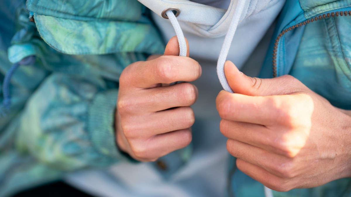 Hände halten Kordel an einem Pullover