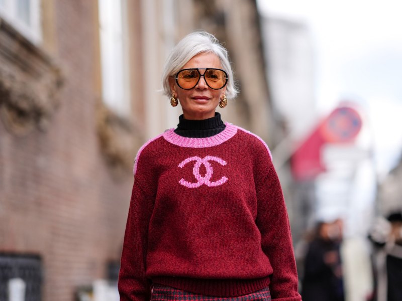 Frau mit einem roten Trend-Pullover und einer stylischen Sonnenbrille