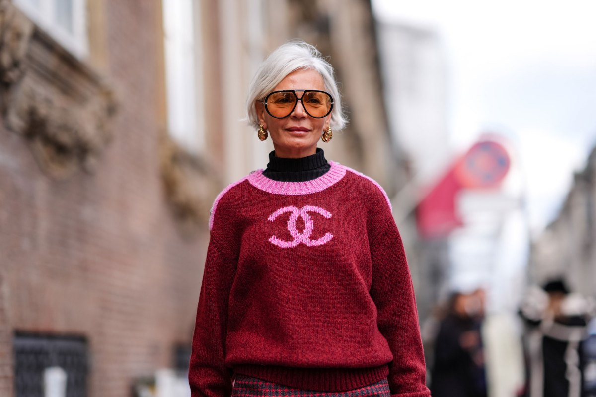 Frau mit einem roten Trend-Pullover und einer stylischen Sonnenbrille