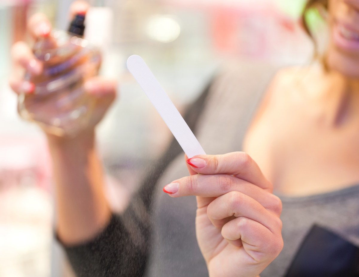 Frau testet Parfum in der Drogerie