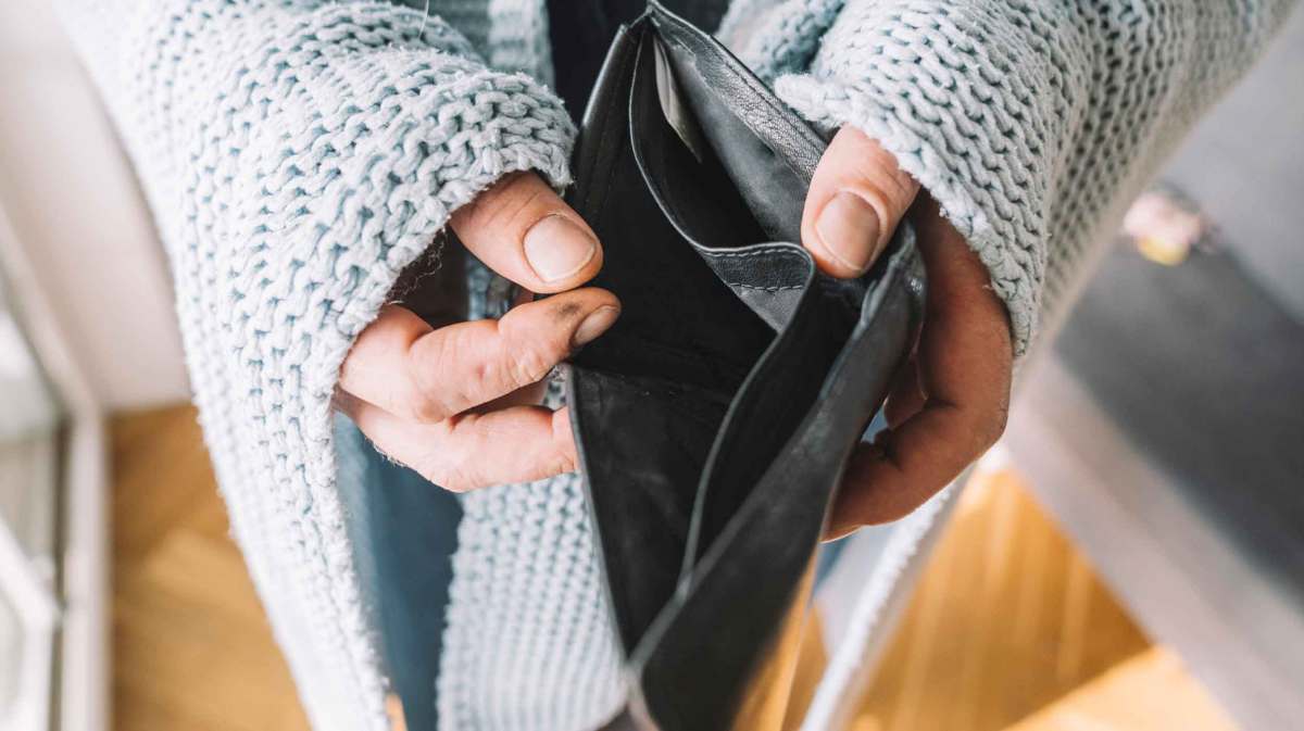 Frau hält ein leeres Portemonnaie in den Händen.