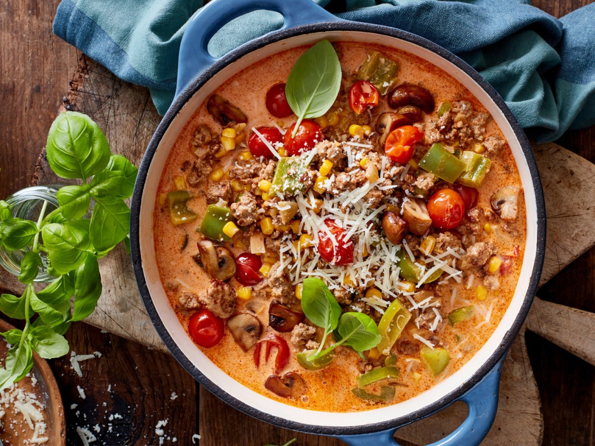 Pizza-Eintopf mit Hackfleisch, Mais und Paprika in einem großen Topf.