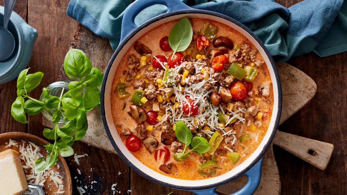 Pizza-Eintopf mit Hackfleisch, Mais und Paprika in einem großen Topf.