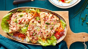 Schnitzel überbacken mit Flammkuchen Topping auf Salatbett.