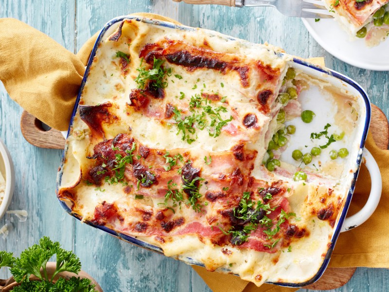 Lasagne Carbonara in einer Auflaufform auf Holztisch.