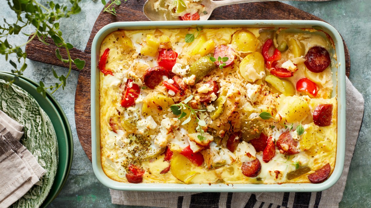 Sauerkraut Auflauf mit Kartoffeln und Kabanossi in einer Auflaufform.