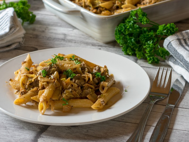 Spitzkohlpfanne mit Hackfleisch und Nudeln auf einem weißen Teller.